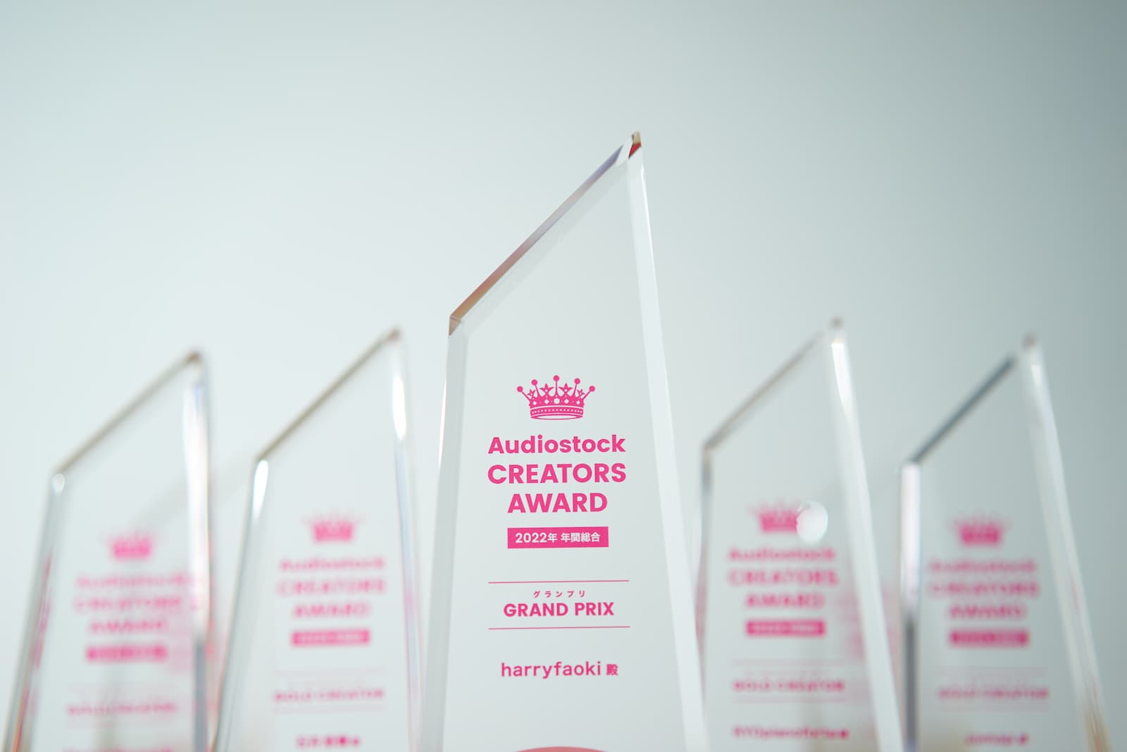 「Audiostock CREATORS AWARD」と刻印されたクリスタルトロフィーの写真。それぞれの賞とクリエイターの名前も併せて刻印されている。